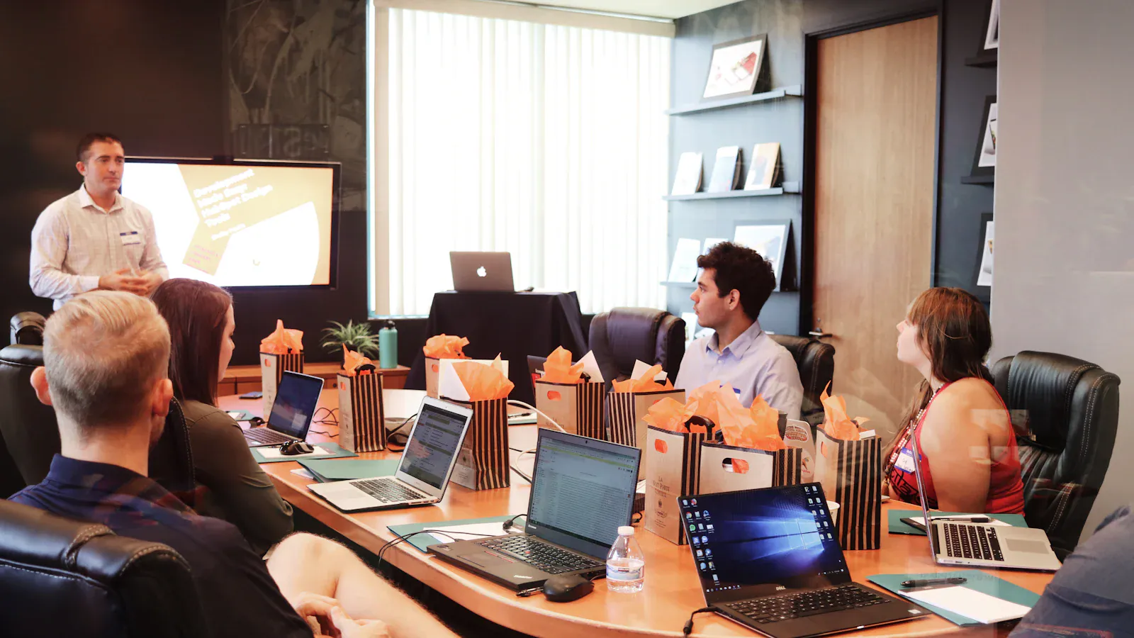 Trainer presenting to a team working on laptops in a meeting room